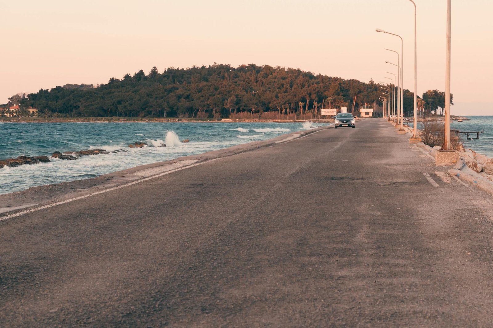 Serene coastal road with ocean view during sunset in Urla, İzmir, Türkiye. Perfect for relaxation and travel inspiration.